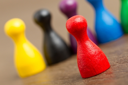 Six colored pawns isolated on a wooden backgroundの写真素材