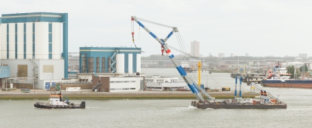 ROTTERDAM, THE NETHERLANDS - JUNE 22: Close-up of a tugboat dragging a crane in the busy port of Rotterdam, Rotterdam, Holland, June 22, 2012のeditorial素材
