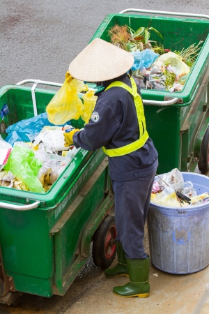 DA LAT, VIETNAM - 28 JULY 2012: Government worker separates the waste on the street for recycling. Pollution is a big problem in Vietnam nowadays. Vietnam, 2012のeditorial素材