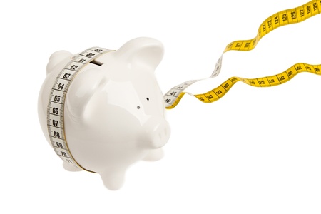 White piggy bank with measuring tape on white backgroundの写真素材