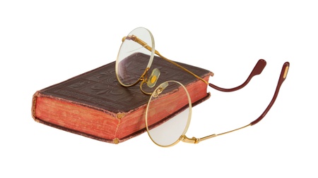 Very old glasses and a red book isolated on white backgroundの写真素材