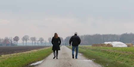 Man and woman walking on a roadの写真素材