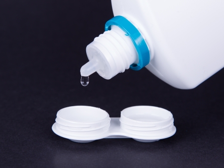 Lens casing and bottle of water isolated on black, contact lensesの写真素材