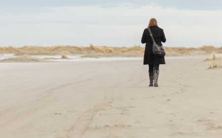 Lonely woman walking on a beach in Hollandの写真素材