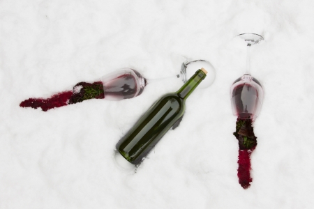 Bottle of red wine and wineglasses isolated in the cold snowの写真素材