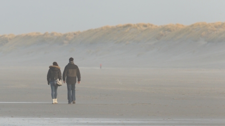 Couple walking on a dutch beach in the winterの写真素材