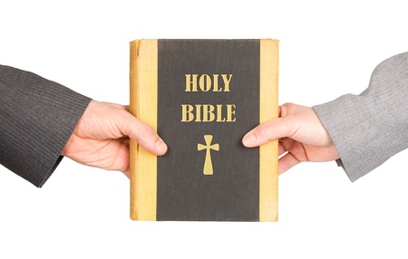Man and woman in business suits are holding a holy bible, close-up