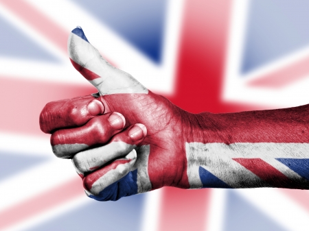 Union Jack on thumbs up hand isolated on a flag backgroundの写真素材