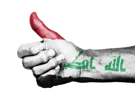 Old woman with arthritis giving the thumbs up sign, wrapped in flag pattern, Iraqの写真素材