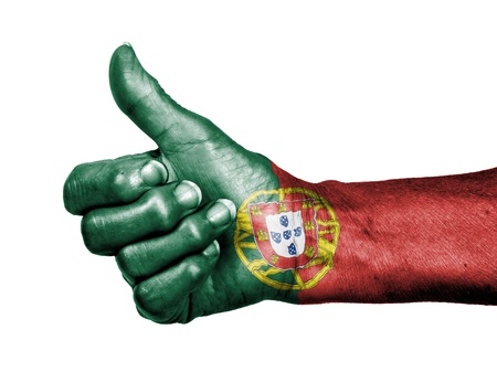 Old woman with arthritis giving the thumbs up sign, wrapped in flag pattern, Portugalの写真素材
