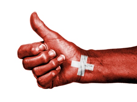 Old woman with arthritis giving the thumbs up sign, wrapped in flag pattern, Switzerlandの写真素材