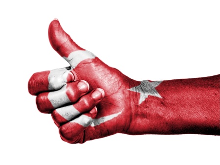 Old woman with arthritis giving the thumbs up sign, wrapped in flag pattern, Turkeyの写真素材