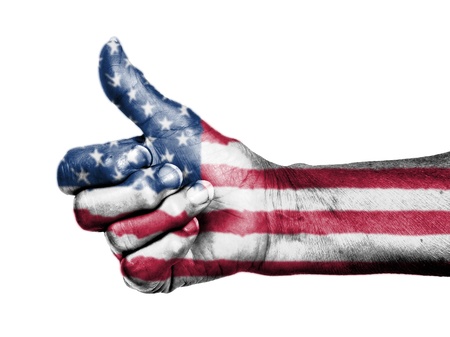 Old woman with arthritis giving the thumbs up sign, wrapped in flag pattern, United States of...