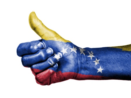 Old woman with arthritis giving the thumbs up sign, wrapped in flag pattern, Venezuelaの写真素材