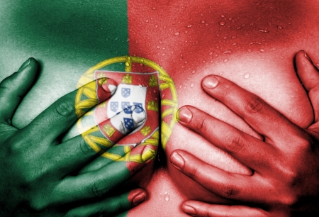 Sweaty upper part of female body, hands covering breasts, flag of Portugalの写真素材