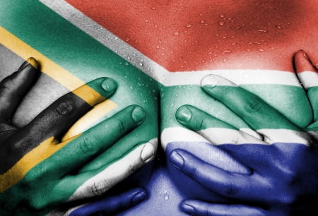 Sweaty upper part of female body, hands covering breasts, flag of South Africaの写真素材