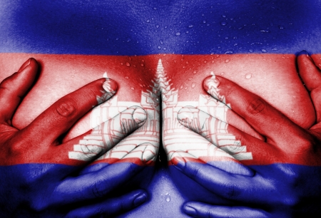 Sweaty upper part of female body, hands covering breasts, flag of Cambodiaの写真素材