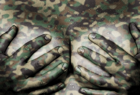 Sweaty upper part of female body, hands covering breasts, camouflagedの写真素材