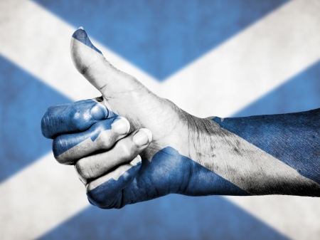 Old woman with arthritis giving the thumbs up sign, isolated on white, Scotlandの写真素材