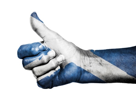 Old woman with arthritis giving the thumbs up sign, isolated on white, Scotlandの写真素材