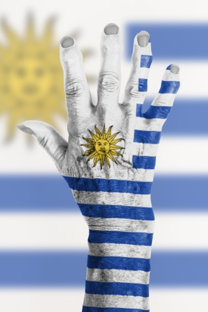 Hand of an old woman wrapped in flag of Uruguayの写真素材