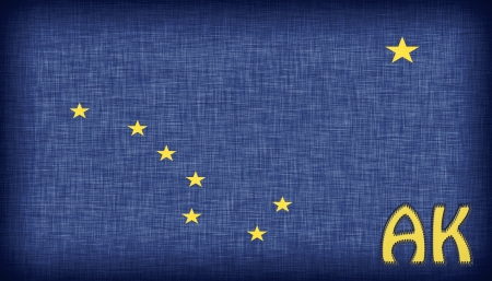 Linen flag of the US state of Alaska with it's abbreviation stitched on itの写真素材