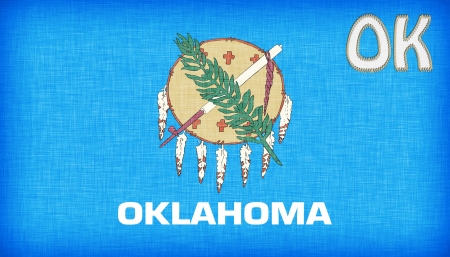 Linen flag of the US state of Oklahoma with it's abbreviation stitched on itの写真素材
