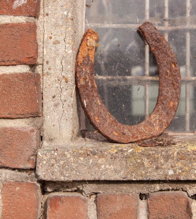 Single horseshoe in front of a window, bringing luckの写真素材