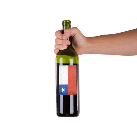 Hand holding a bottle of red wine, label of Chile, isolated on white,の写真素材