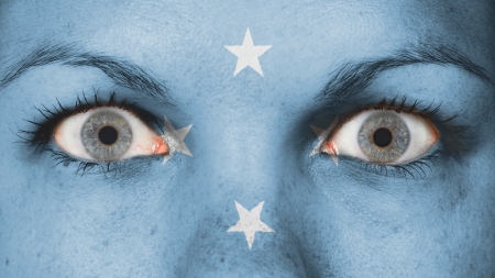 Close up of eyes. Painted face with flag of Micronesiaの写真素材