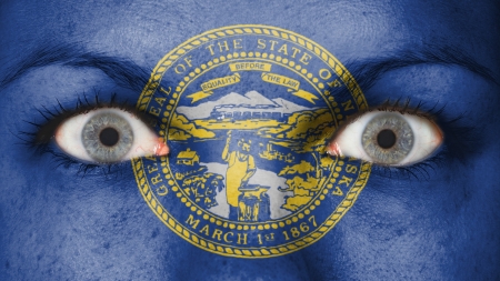 Close up of eyes. Painted face with flag of Nebraskaの写真素材