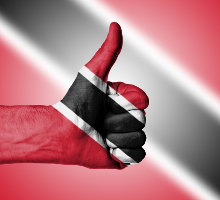 Closeup of male hand showing thumbs up sign, flag of Trinidad and Tobagoの写真素材