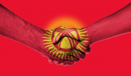 Man and woman shaking hands, wrapped in flag pattern, Kyrgyzstanの写真素材