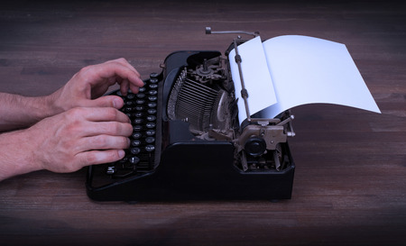Writer or reporter behind the typewriter in retrostyle