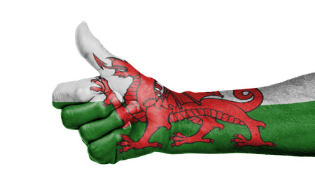 Old woman with arthritis giving the thumbs up sign, isolated on white, flag of Walesの写真素材