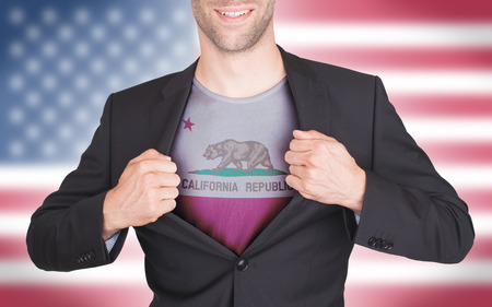 Businessman opening suit to reveal shirt with state flag (USA), Californiaの写真素材