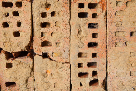 Four old bricks with holes on a row