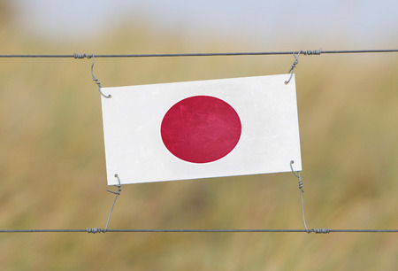 Border fence - Old plastic sign with a flag - Japanの写真素材