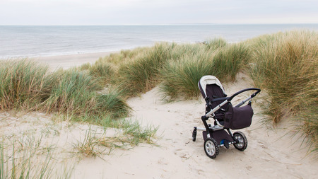Baby stroller standing at a beach in the Netherlandsの写真素材