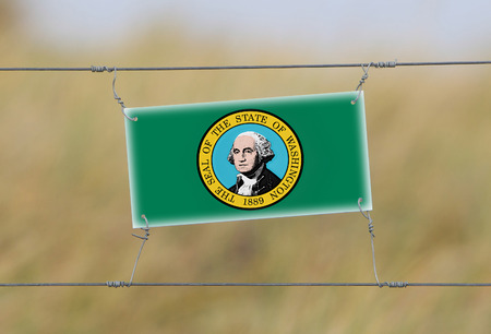 Border fence - Old plastic sign with a flag - Washington