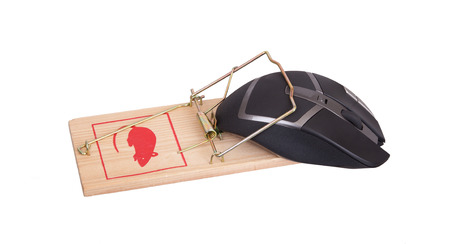 Modern computer mouse in a mousetrap against white backgroundの写真素材