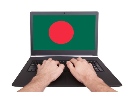 Hands working on laptop showing on the screen the flag of Bangladeshの写真素材