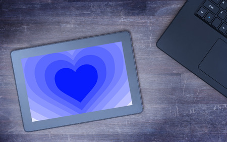 Heart shape backgound on a tablet - Concept of love - blueの写真素材