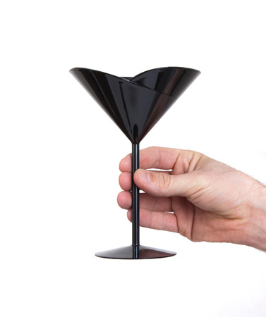 Black plastic coctail glass in hand, isolated on whiteの写真素材