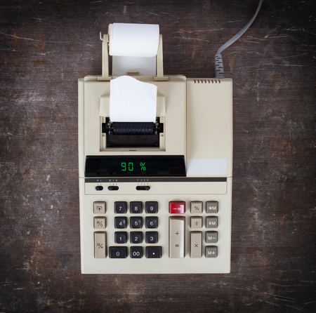 Old calculator with digital display showing a percentage - 90 percentの写真素材