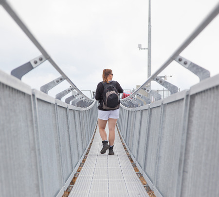 Hiker, young woman with backpack walking on footpath, Switzerlandのeditorial素材