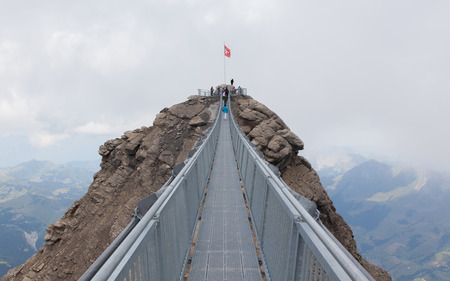 LES DIABLERETS, SWIZTERLAND - JULY 22: People walk at the Glacier 3000 on July 22, 2015. The area houses the world only suspension bridge between 2 mountain peaks.のeditorial素材