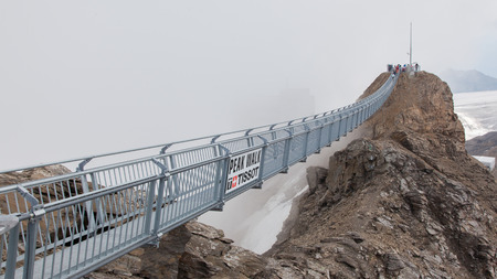 LES DIABLERETS, SWIZTERLAND - JULY 22: People walk at the Glacier 3000 on July 22, 2015. The area houses the world only suspension bridge between 2 mountain peaks.のeditorial素材