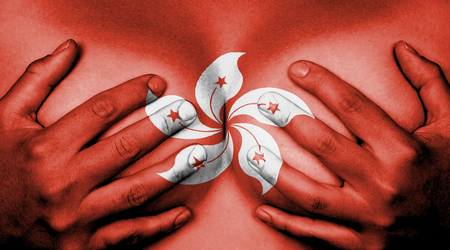 Upper part of female body, hands covering breasts, flag of Hong Kongの写真素材