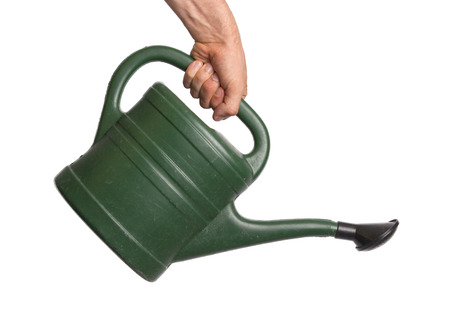 Hand holding green watering can, isolated on whiteの写真素材